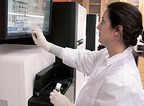 Research technician Maggie O'Guinn prepares a DNA sequencer.