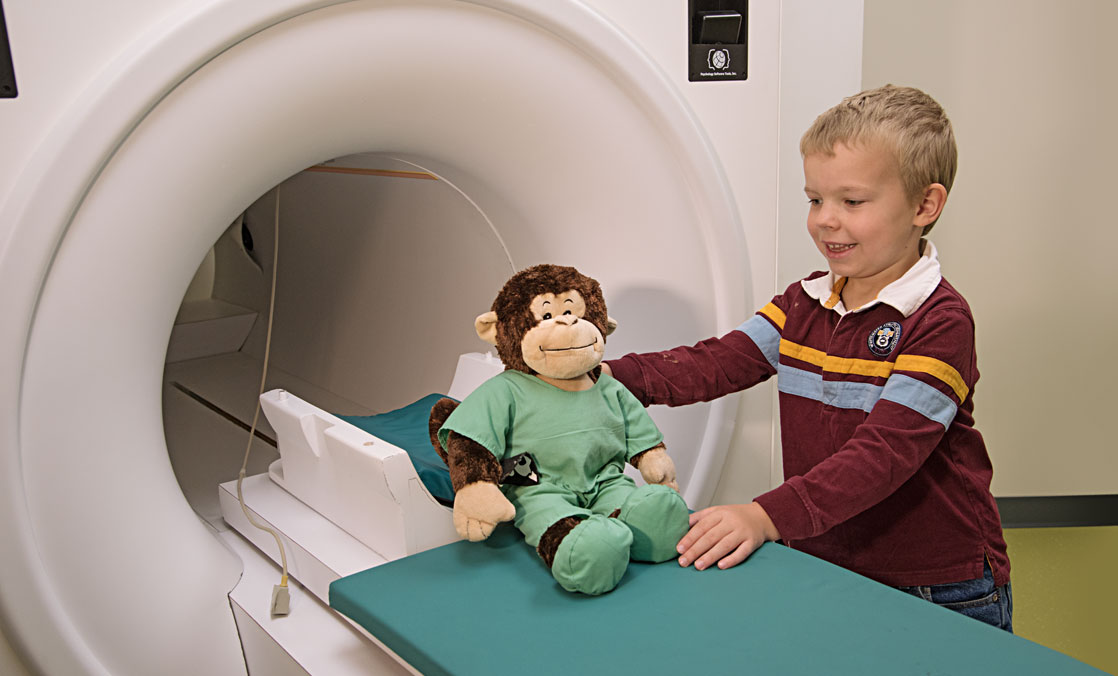 Enclosed scanners are often unnerving for adults, much less these young children who must hold still and perform basic tasks while inside the noisy machines. So the researchers have developed a novel approach. Children undergo “practice scans” first with a device that looks like the real thing, all in a playful environment that helps overcome anxieties.