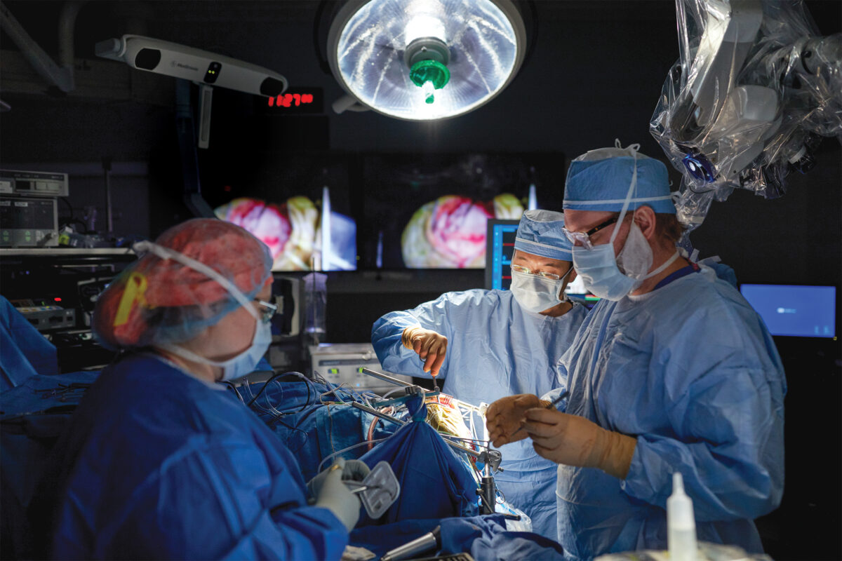 Three doctors perform brain surgery on a patient. 